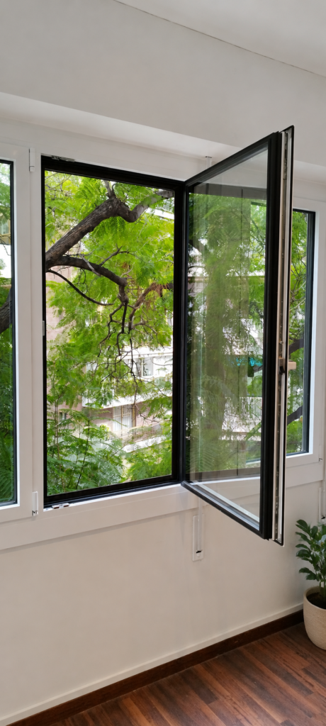 Ventana practicable de aluminio abierta con herraje de cierre